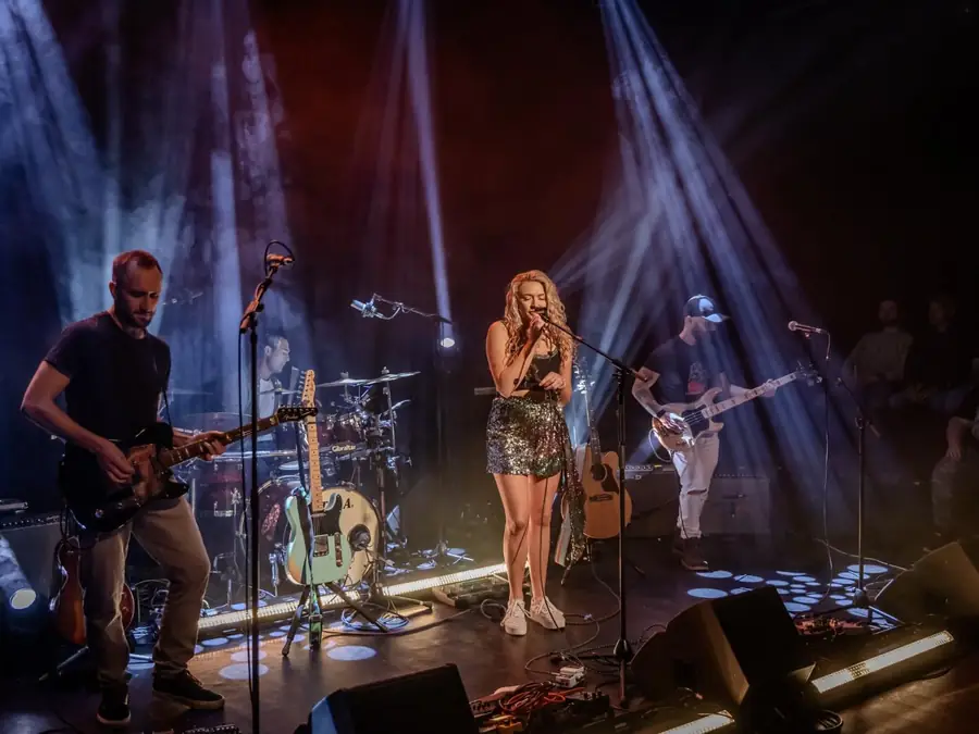 Maddison performing on stage with her band